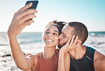 Selfie kiss, love and couple with a phone for streaming, training and care at the beach in Bali. Gratitude, exercise and affectionate man and woman with a smile for a mobile photo after a workout