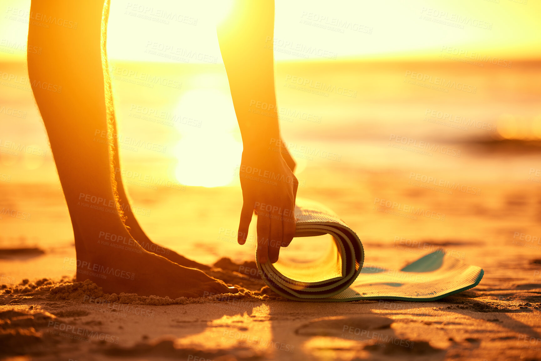 Buy stock photo Hands, beach and woman roll yoga mat getting ready for workout, exercise or stretching at sunset. Zen, meditation and feet of female yogi outdoors on seashore while preparing for training and pilates