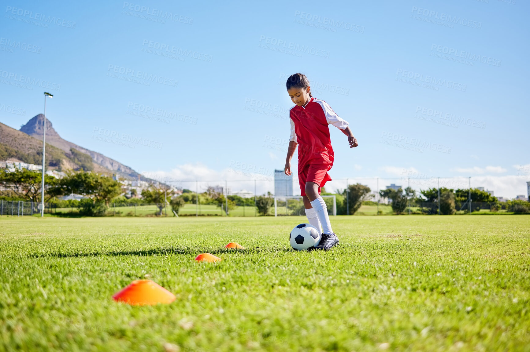 Buy stock photo Football girl kid, training and grass for fitness, speed or balance with sport talent development, control and speed. Female child, fast football dribbling or motivation mindset on field in Cape Town