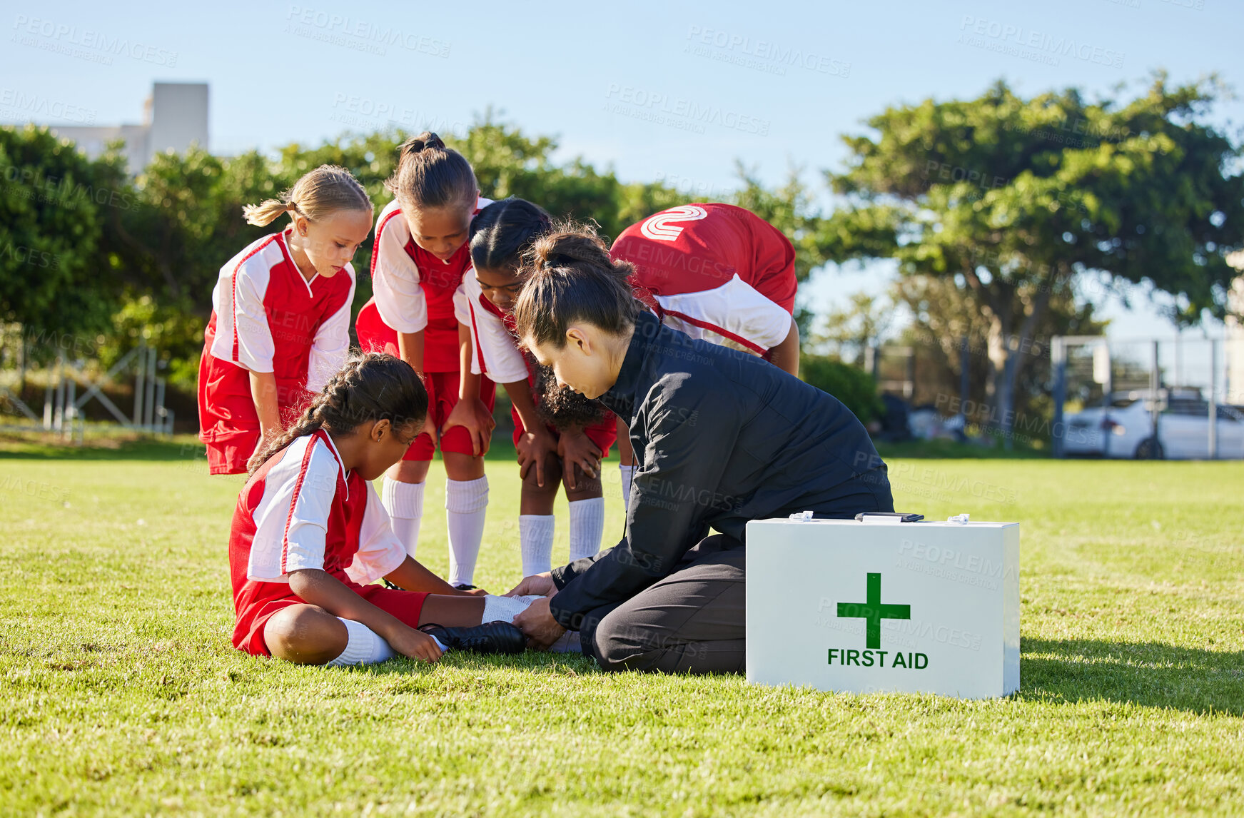 Buy stock photo Sports, first aid and children soccer team with an injury after a game in a huddle helping a girl athlete. Fitness, training and kid with a sore, pain or muscle sprain on an outdoor football field.