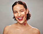 Beauty, face and woman lipstick and wink with kiss print on skin, flirt and sexy, tongue out isolated on studio background. Red, lips and smile with skincare, makeup mockup, fun and cosmetic care