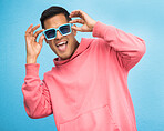 Happiness, man with sunglasses and smile with face, trendy fashion and happy with freedom isolated on blue background. Funky, retro and wellness, hipster person in studio with vintage designer brand