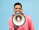 Portrait, protest and megaphone with a man in studio on a blue background for an announcement or speech. Freedom, human rights and loudspeaker with a male at a rally for equality or revolution