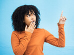 Black woman, surprise face and pointing in studio for news, announcement or gossip notification by blue background. Gen z girl, young african model and fashion with wow hand sign for hearing secret