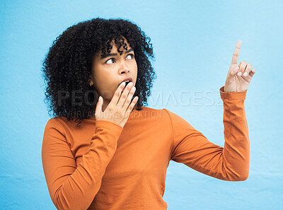 Buy stock photo Black woman, surprise face and pointing in studio for news, announcement or gossip notification by blue background. Gen z girl, young african model and fashion with wow hand sign for hearing secret