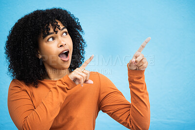 Buy stock photo Black woman, surprise and pointing hands in studio for news announcement, gossip notification and blue background. African gen z girl, young female model and fashion for wow, hand sign and happiness