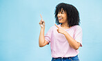 Mock up, studio and happy black woman point at sales promo, discount gift deal or mockup space. Female advertising gesture, marketing product placement and African model isolated on blue background
