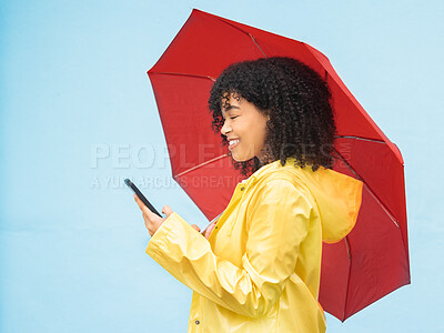 Buy stock photo Phone, umbrella and mockup with a black woman in studio on a blue background for insurance or communication. Mobile, winter and mock up with an attractive young female typing a text message