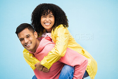 Buy stock photo Happy people, bonding and piggyback portrait on isolated blue background in travel, date or fun game. Smile, man and carrying black woman in playful, silly or goofy trust for love couple in support