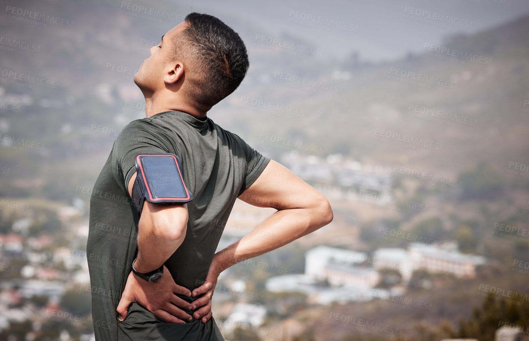 Buy stock photo Fitness, pain and man with hands on back, hurt muscle on run with smartphone running tracker. Health, exercise and outdoor workout, runner with injury, tension or painful muscles on marathon training