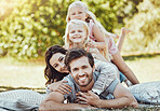 Family, park and portrait of parents, children and happy people on garden grass in sunshine. Kids, mom and dad smile with love in nature, picnic and summer vacation to relax on lawn with happiness 