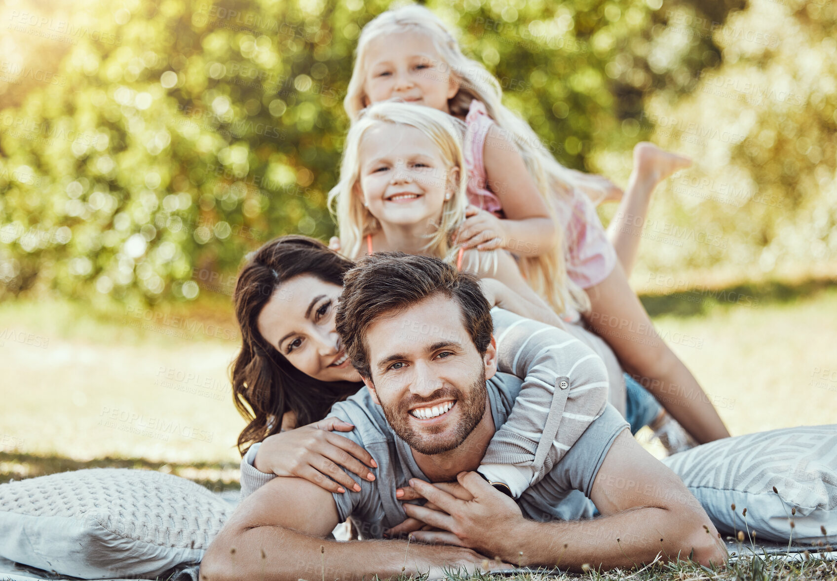 Buy stock photo Family, park and portrait of parents, children and happy people on garden grass in sunshine. Kids, mom and dad smile with love in nature, picnic and summer vacation to relax on lawn with happiness 
