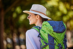 Woman, backpack or sightseeing in nature travel, park adventure or trees forest in Canada woods. Smile, happy or tourist with hiking hat, bag or fitness gear in countryside location for camping trip