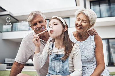 Buy stock photo Smile, family and girl with bubbles and grandparents enjoying weekend, holiday and quality time together. Love, home and happy girl, grandmother and grandfather bonding, relaxing and fun in garden