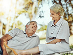 Retirement, love and picnic with a mature couple outdoor in nature to relax on a green field of grass together. Happy, smile and date with a senior man and woman bonding outside for romance