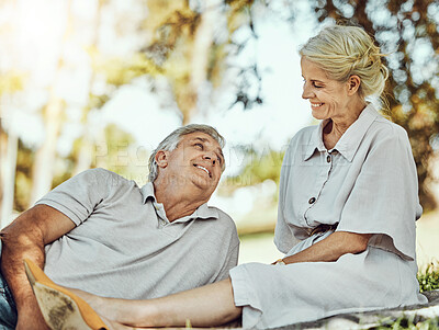 Buy stock photo Retirement, love and picnic with a mature couple outdoor in nature to relax on a green field of grass together. Happy, smile and date with a senior man and woman bonding outside for romance