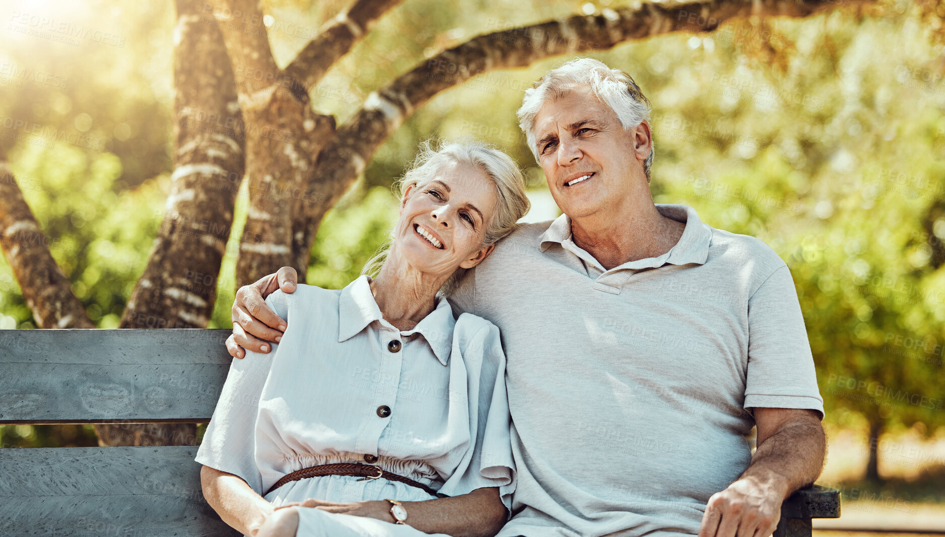 Buy stock photo Love, relax and old couple on bench in park with smile, embrace and bonding time in nature together. Romance, senior man and retired woman sitting in garden, happy people and romantic summer weekend.