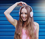 Music, headphones and blue background with a woman listening to or streaming audio for fun. Radio, internet and 5g with an attractive young female using wireless technology to listen to a song