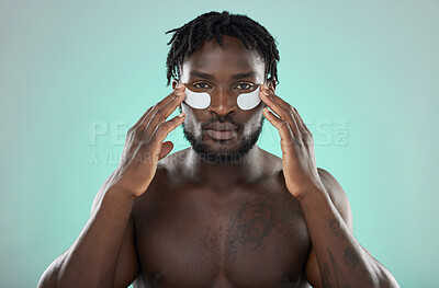 Buy stock photo Skincare, eye pads and black man in studio for healthy, cosmetic and natural face routine. Health, wellness and portrait of an African guy with a facial treatment by blue background with mockup space