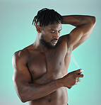 Body hygiene and black man with deodorant spray product for self care routine of people in studio. Health, wellness and cosmetic grooming of person with skincare at isolated green background.


