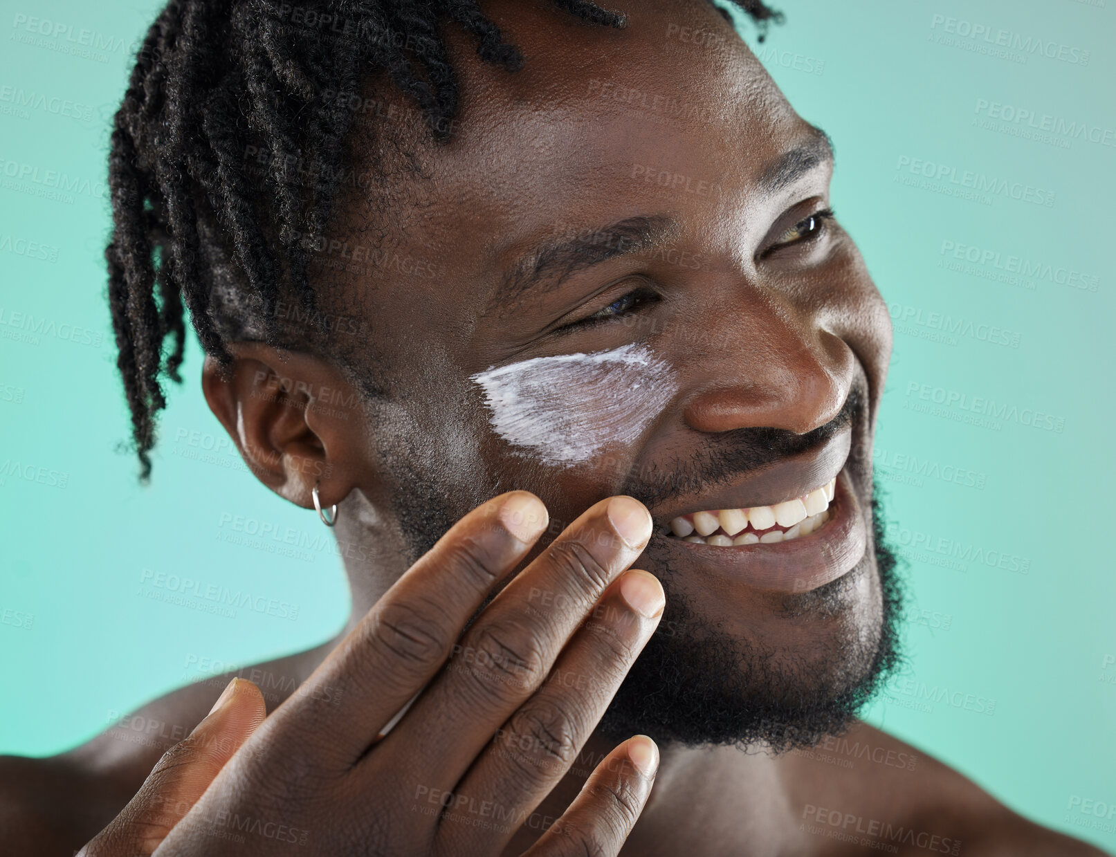 Buy stock photo Black man, face and cream, happy with smile and beauty, moisturizer for skincare isolated on studio background. Healthy skin, cosmetic care and model apply lotion, facial and wellness with cosmetics
