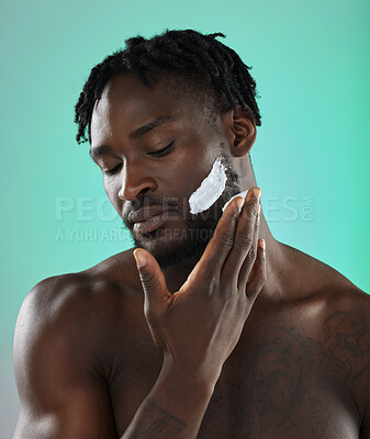 Buy stock photo Black man with shaving cream, skincare product on face in studio background and smooth facial hair. Young african model grooming, male hygiene and cleaning beard with cosmetic morning routine