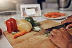 Kitchen, cutting board and vegetables being cut for cooking a healthy, organic and delicious meal. Food, nutrition and chef chop or preparing fresh produce peppers for a diet dinner, lunch or supper.