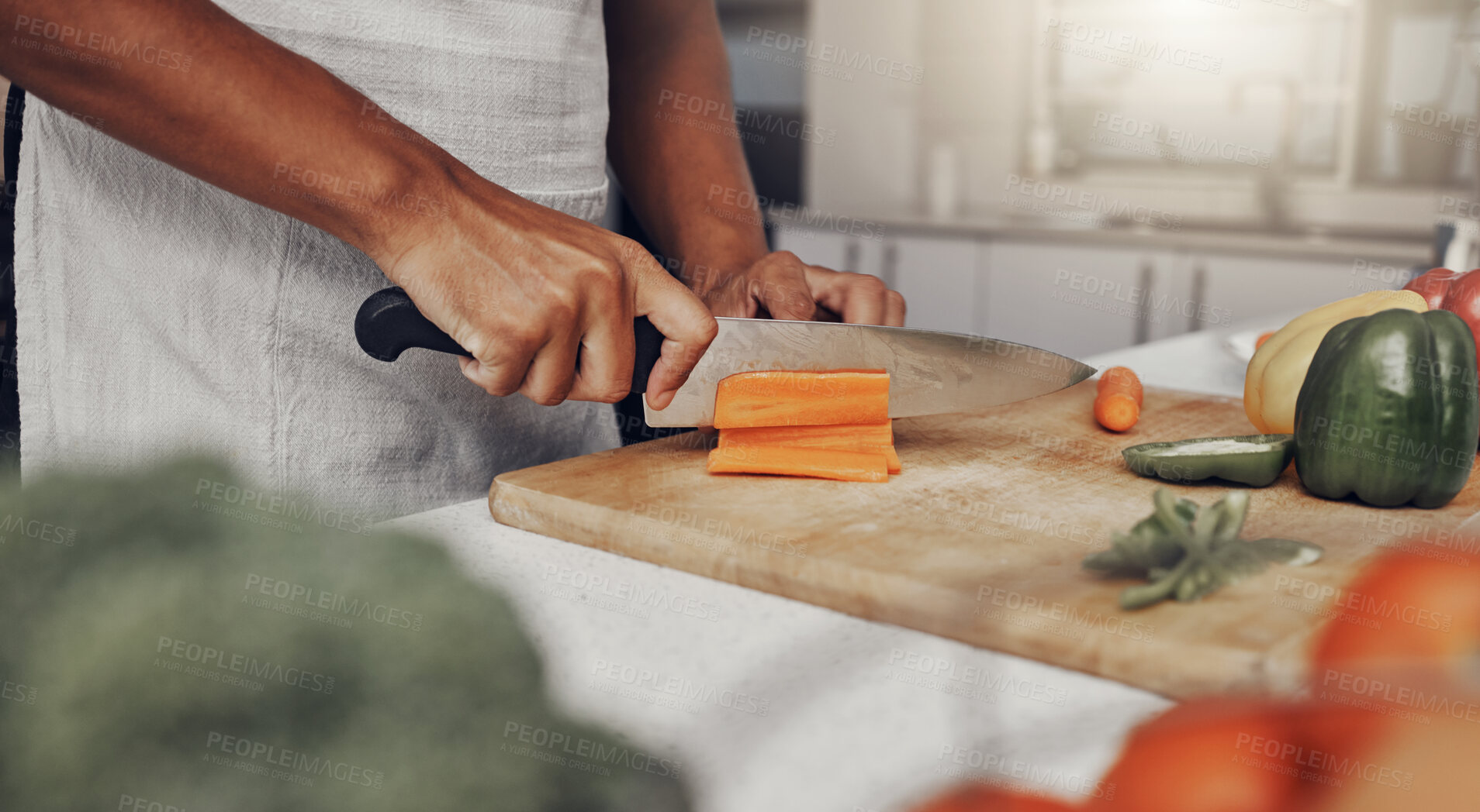 Buy stock photo Hands, food and nutrition with a man cooking in the kitchen while cutting vegetables on a wooden chopping board. Salad, health or diet with a chef preparing a meal while standing alone in his home