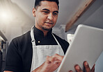 Man with apron, focus and tablet for online recipe, cooking instructions and connection in kitchen. Male, chef and gentleman with device, communication and search for ingredients, thinking and ideas