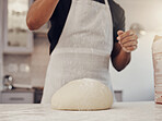 Chef man and flour sprinkle on dough for baking preparation work and process at culinary counter. Restaurant worker in professional kitchen preparing wheat bread, cake or pizza recipe. 

