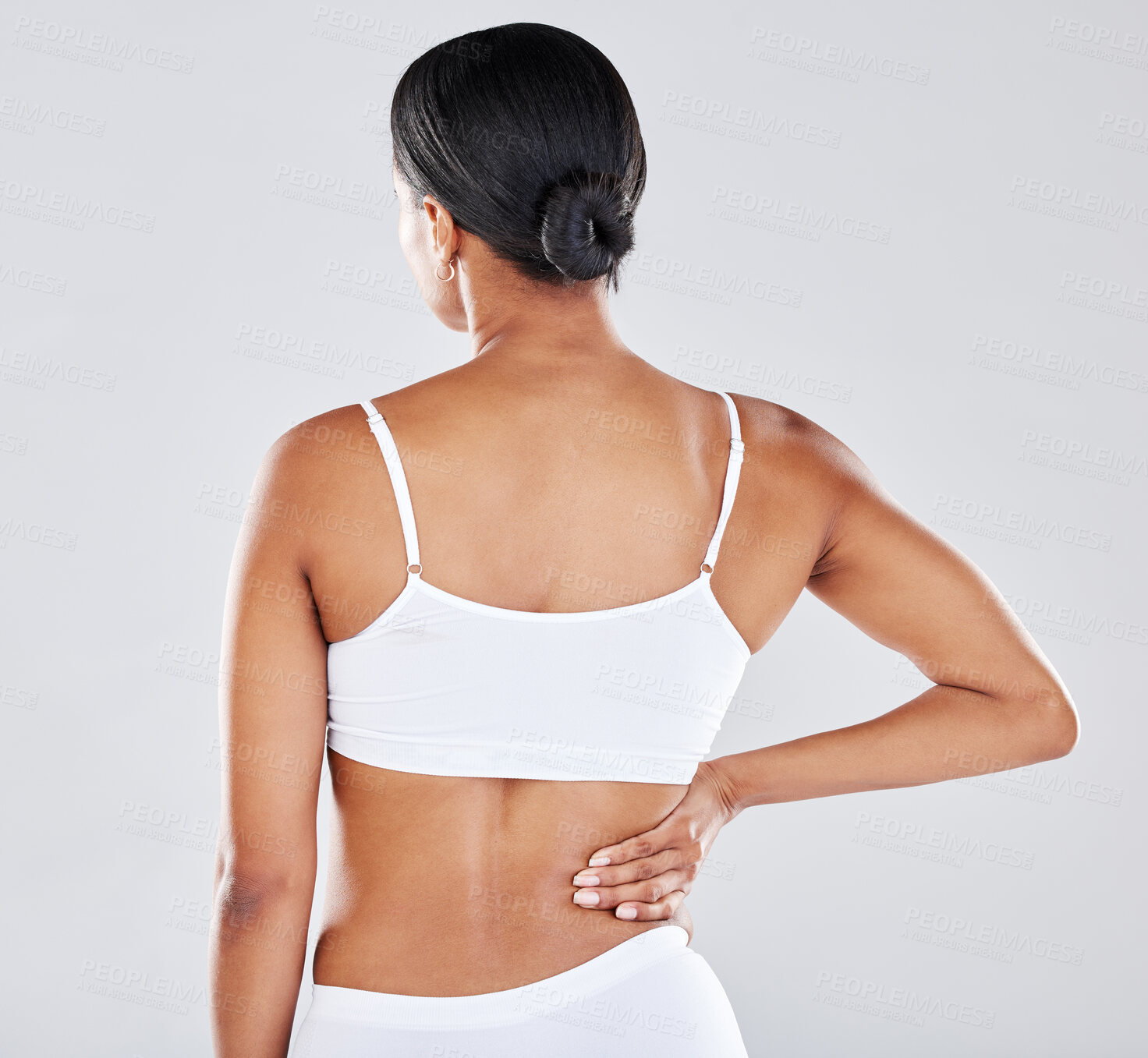 Buy stock photo Back, body and pain with a model black woman holding her side in studio on a gray background while suffering from injury. Medical, health and anatomy with a female in underwear rubbing her muscle