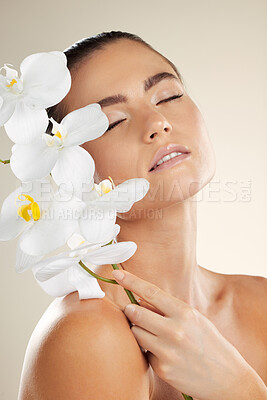 Buy stock photo Skincare, beauty and woman with orchid flower on skin for natural dermatology cosmetic product. Glow on face of aesthetic model in studio for sustainable floral plant for makeup and spa wellness