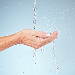 Senior hands, water splash for clean hygiene, fresh minerals or wash against a studio background. Hand of elderly holding natural liquid drops for skin hydration, wellness or safety from bacteria