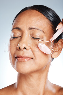 Buy stock photo Face, elderly woman with roller and massage, antiaging skincare with beauty zoom isolated on studio background. Facial, cosmetic tools and dermatology with natural cosmetics and skin wellness