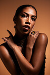 Elegant, vintage and portrait of a beautiful woman isolated on a brown studio background. Fashion, sexy and body of a young retro model with classy jewelry, style and fashionable on a backdrop