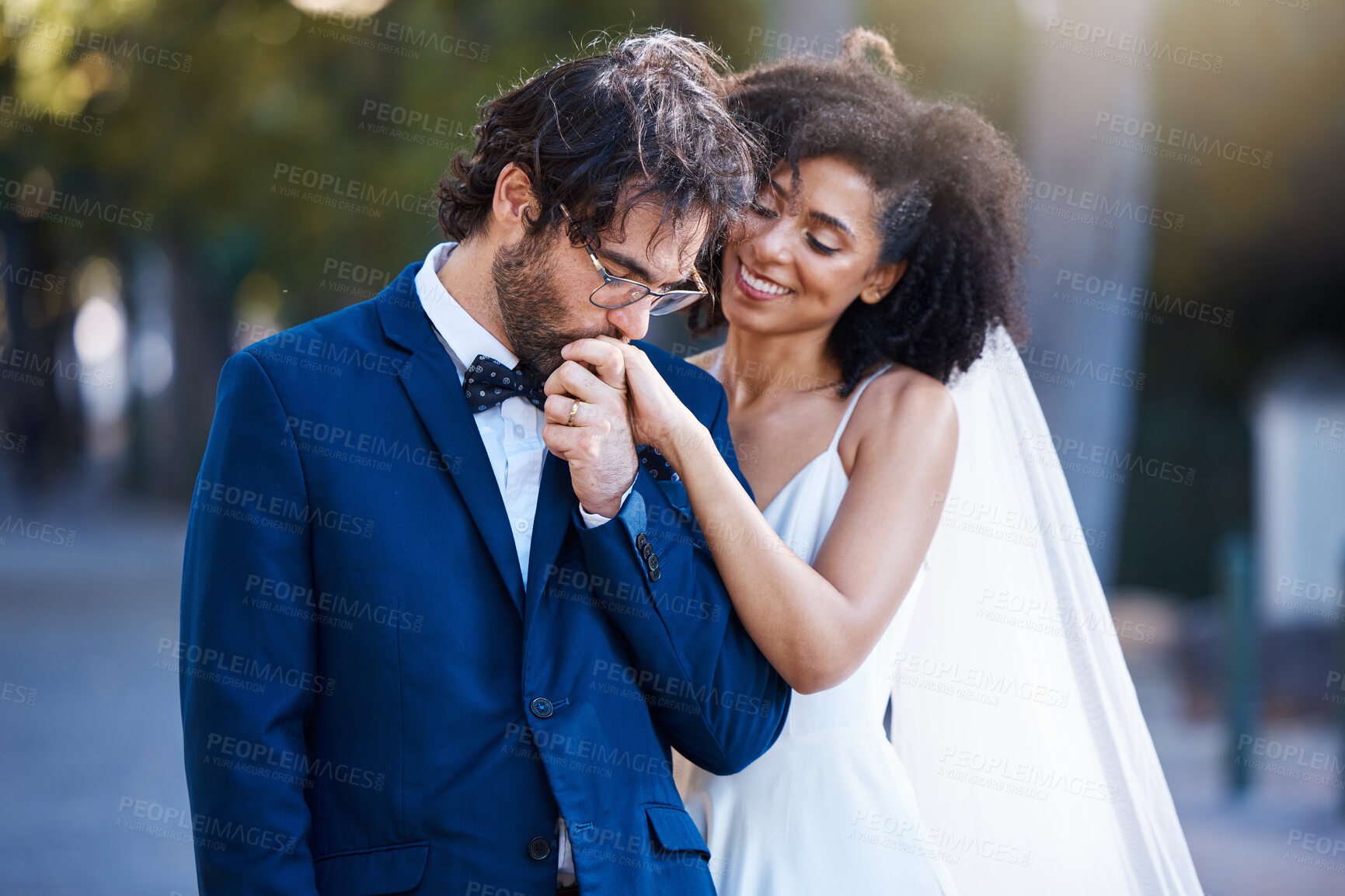 Buy stock photo Wedding, happy couple and kiss on hand at marriage celebration event together with commitment. Interracial man and woman at ceremony with trust, partnership and care while outdoor with flower bouquet
