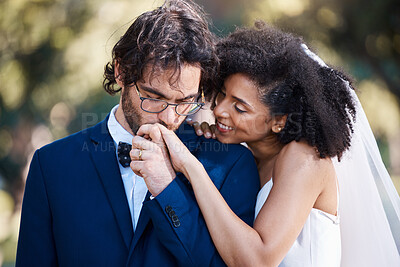 Buy stock photo Wedding, kiss on hand and happy couple outdoor for marriage celebration event together with commitment. Interracial man and woman at ceremony with trust, partnership and respect with smile from bride