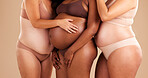 Pregnant women, diversity or stomach on studio background in body love, baby or community support. Pregnancy hands, tummy or family planning for people, models or mothers in underwear or future life