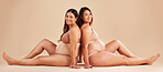 Friends, pregnancy and studio portrait for underwear, smile and women sitting together for support on floor. Happy future mom, pregnant or solidarity for health, love or healthy stomach by background