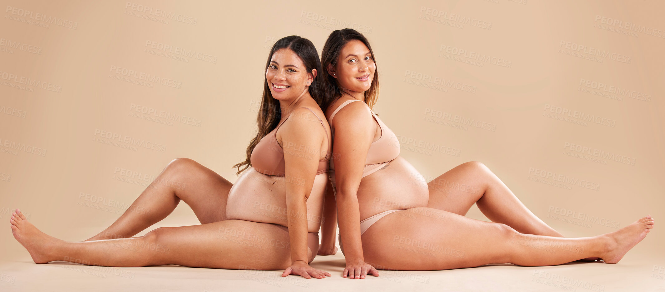 Buy stock photo Friends, pregnancy and studio portrait for underwear, smile and women sitting together for support on floor. Happy future mom, pregnant or solidarity for health, love or healthy stomach by background