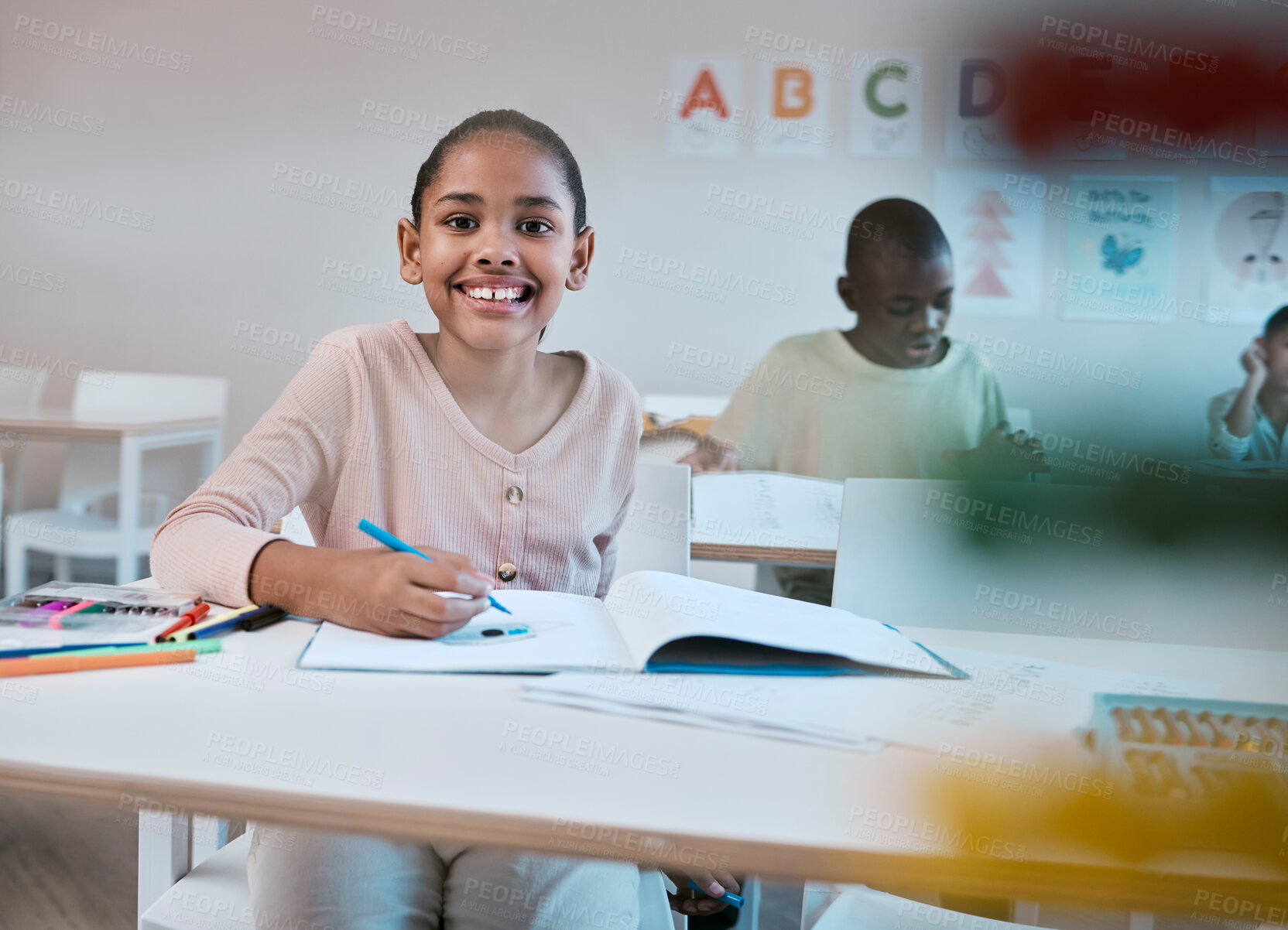 Buy stock photo Education, class and portrait of child with smile in classroom learning reading, writing and math in Montessori school. Books, students and happy girl at desk with notebook studying for future exam.