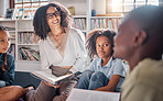 Storytelling, teacher or students with talking in a library asking questions for learning development. Education, kids or children listening to a black woman speaking on fun books at school classroom