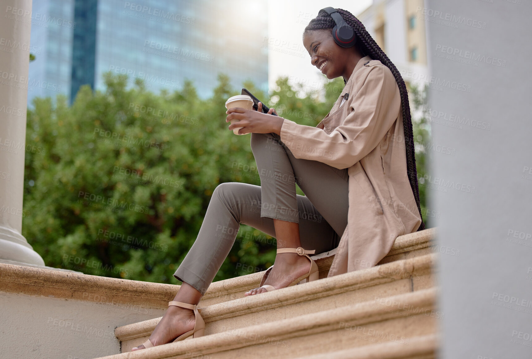 Buy stock photo Music headphones, phone and black woman with coffee while sitting on city steps. Technology, tea break and happy female employee with caffeine and mobile for social media, streaming radio or podcast.