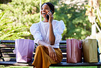 Phone call, happy or black woman with shopping, luxury sale or retail bags in Paris park with smile. 5g network, fashion or girl with smartphone for comic communication or networking in city bench