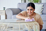 Happy, woman and cleaning living room coffee table with household cloth and satisfied smile. Happiness, focus and concentration of young Indian girl polishing lounge furniture in house. 