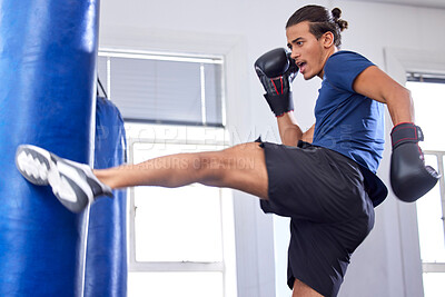 Buy stock photo Kickboxing, fitness and sports with a man fighter training his power in a gym for a competition. Exercise, health and energy with a male kickboxer in a sport facility for a workout on a punching bag