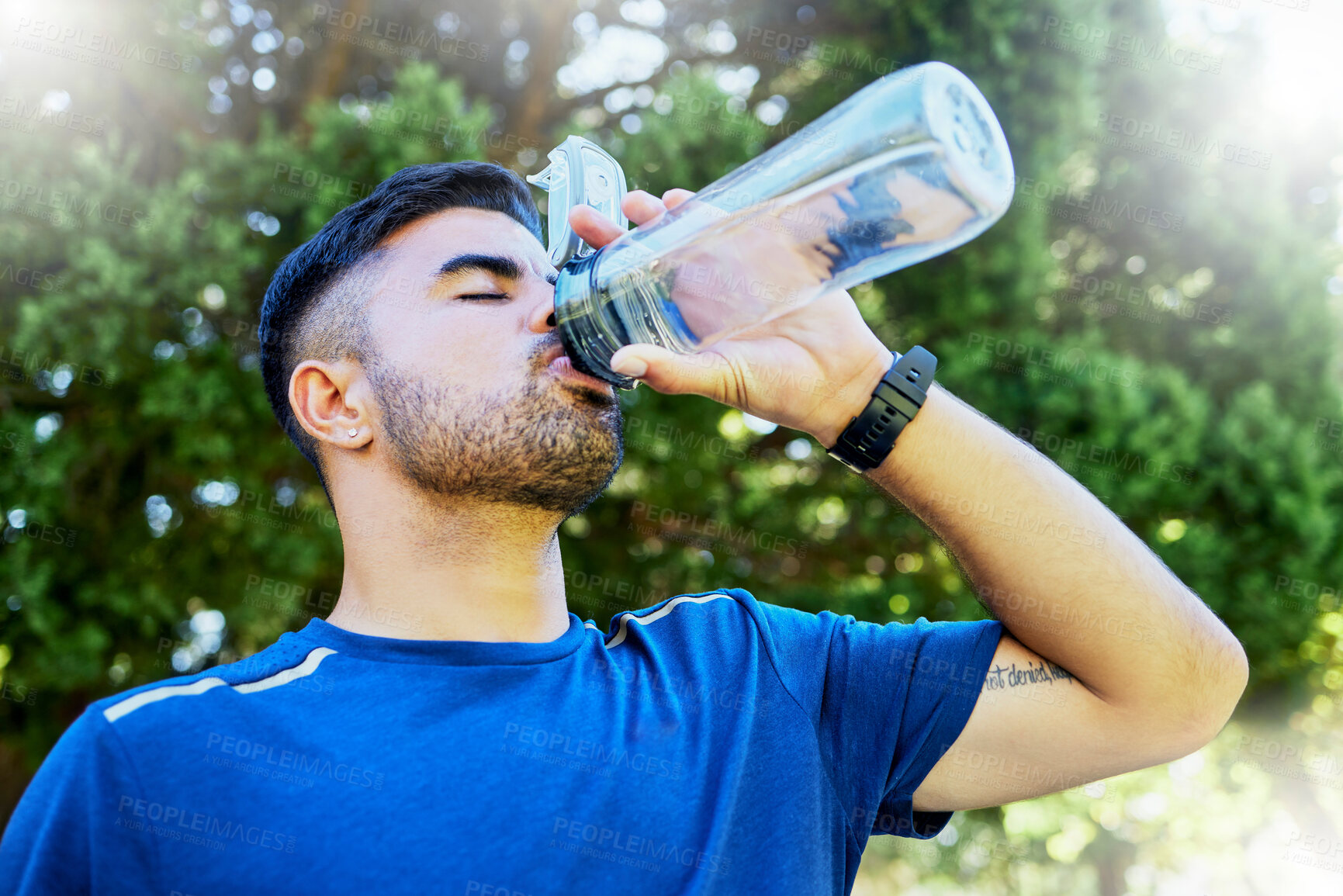 Buy stock photo Nature, drink and runner with water in bottle, relax for thirst on fitness workout in park. Health, exercise and freedom, man drinking in forest while on marathon training run in jungle in Brazil.