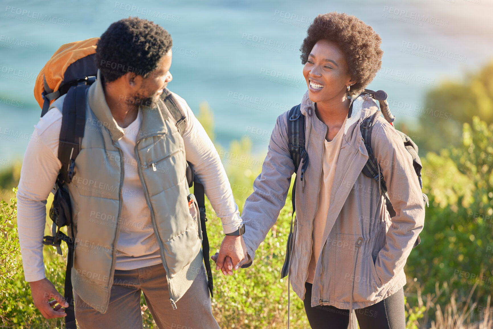 Buy stock photo Black couple, happy and holding hands on hike journey for outdoor exploration, sightseeing and togetherness. Happiness, love and care of people trekking with backpack and smile for travel freedom.