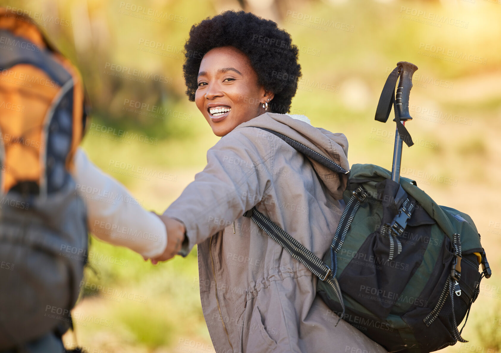 Buy stock photo Black woman, holding hands and hiking with smile for travel, adventure or journey with partner in nature. Happy African American female helping friend on hike in support for trekking challenge