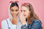 Woman, friends and gossip in shock for secret whisper in ears against pink studio background. Women sharing secrets, rumor or surprise whispering in the ears for hidden story or discount announcement